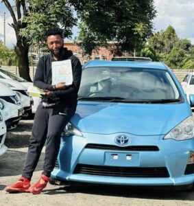 Baba Troy with his new Toyota Aqua car