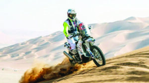 Zimbabwean Motorbike Rider Ashley Thixton while riding bike in sand dunes