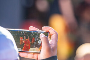 A visitor at the carnival watching recorded performance on his phone