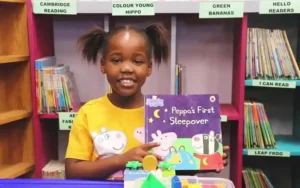 A child named Hlombe Rani Njambatwa showing one of her favourite book