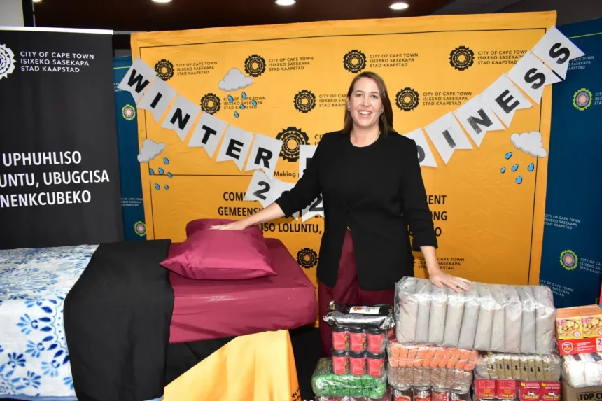 Councillor Francine Higham, addresses guests standing behind key Winter Readiness Programme resources, in Cape Town