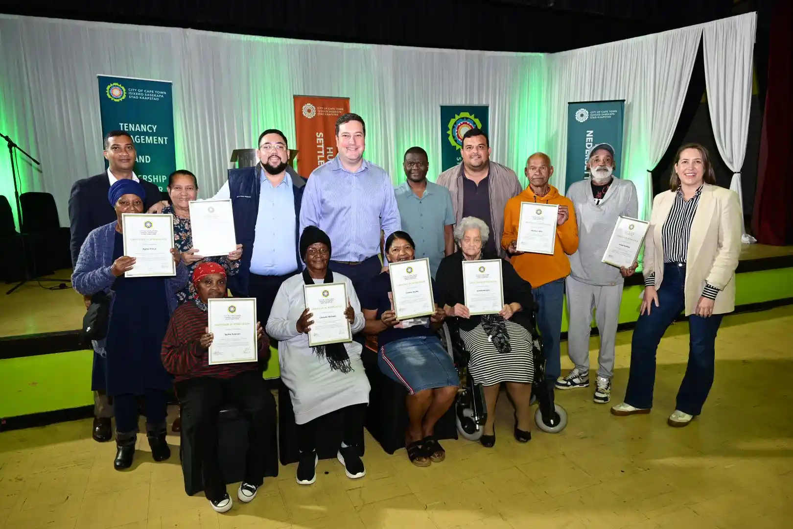 Mayor Geordin Hill-Lewis and Councillor Carl Pophaim with loyal tenants while recognising them in Cape Town