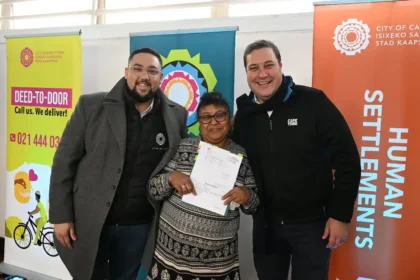 Mayor Geordin Hill-Lewis and Councillor Carl Pophaim with the title deed recipient of the Kensington resident in Cape Town
