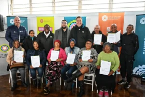 Mayor Geordin Hill-Lewis and Councillor Carl Pophaim with the title deed recipients of the Kensington resident in Cape Town