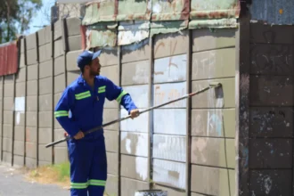 City Graffiti Unit removing paint from Manenberg walls in Cape Town