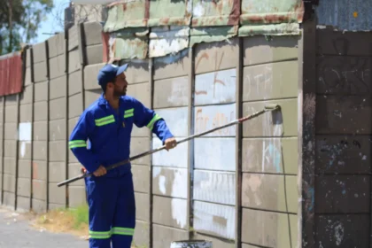 City Graffiti Unit removing paint from Manenberg walls in Cape Town